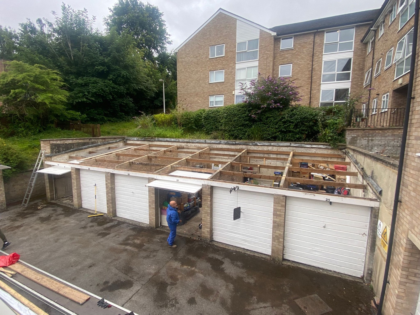 Communal garage block with old roof stripped off — before
